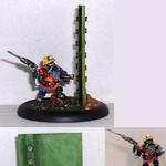 Photo collage of a painted fantasy warrior miniature beside a tall green cactus.
