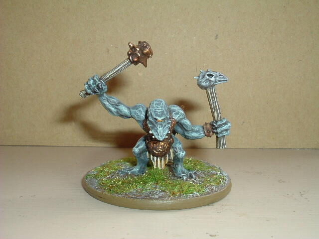 Painted blue-skinned troll miniature on a grassy base, raising a club and hammer.