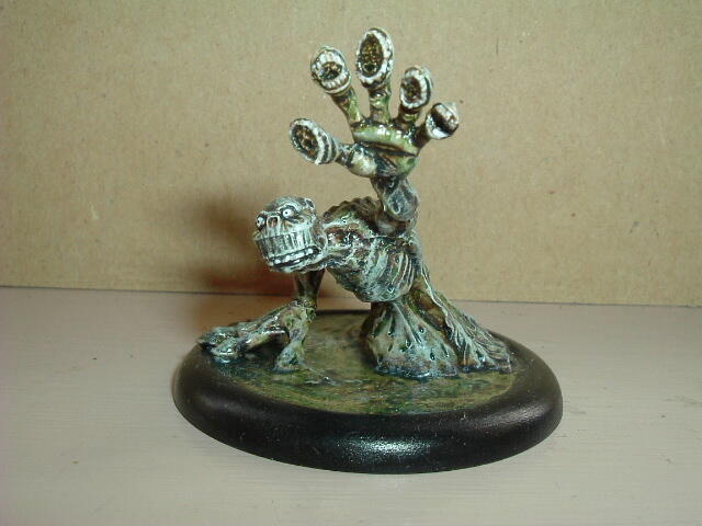 Metal tree sculpture with crystal-like tips on a dark round base.