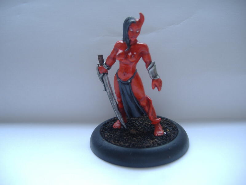 Deadpool figurine holding a sword on a black display base.