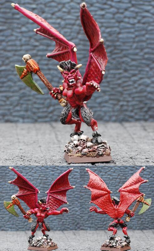 Three views of a red winged dragon miniature holding a spiked axe on a rocky base.