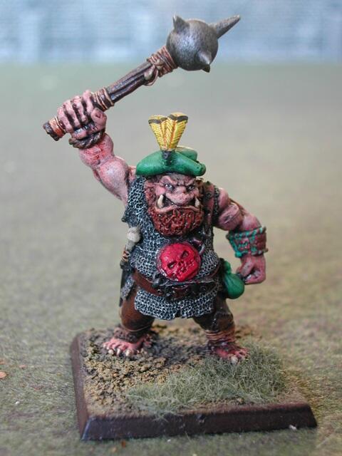 Painted ogre warrior miniature with raised mace on a textured base.