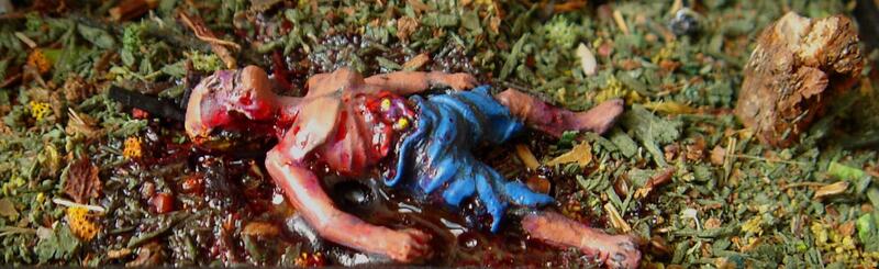 Shirtless person in blue shorts lying on leafy ground, blood visible on the head.