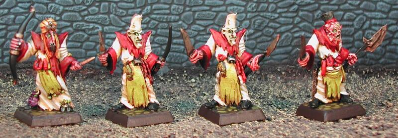 Four painted fantasy miniatures with red wings and yellow robes on square bases.